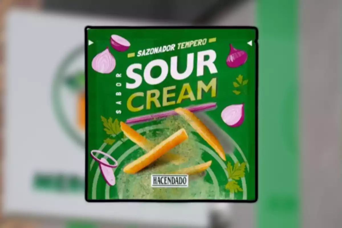 Sobre verde de sazonador sabor sour cream de la marca Hacendado decorado con papas fritas, cebolla morada y hojas de perejil