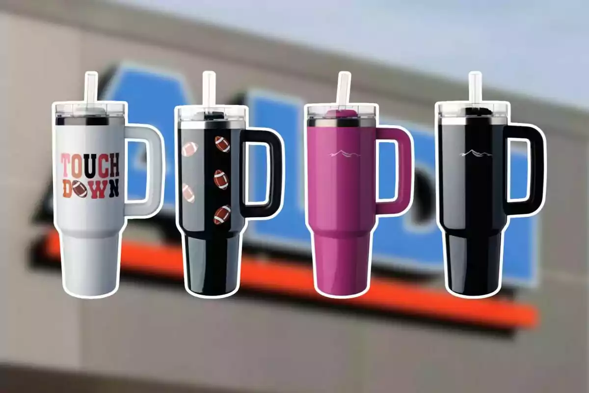 Cuatro vasos térmicos con popote y asa en diferentes colores y diseños están alineados frente a un fondo borroso de una tienda