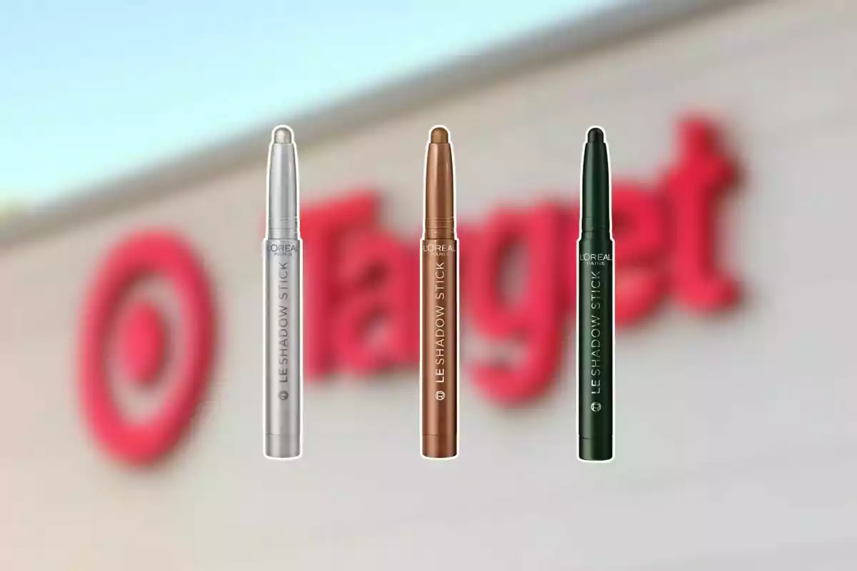 Tres sombras en barra de diferentes colores de la marca L'Oréal flotan frente a un fondo desenfocado de una tienda Target.