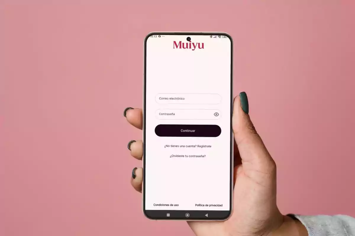Persona sosteniendo un teléfono móvil que muestra la pantalla de inicio de sesión de una aplicación llamada Muiyu sobre un fondo rosa