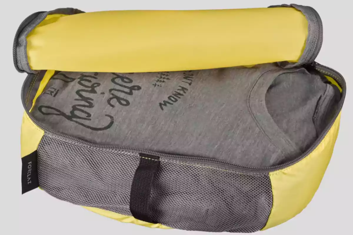 Bolsa organizadora de viaje color amarillo con una camiseta gris doblada en su interior
