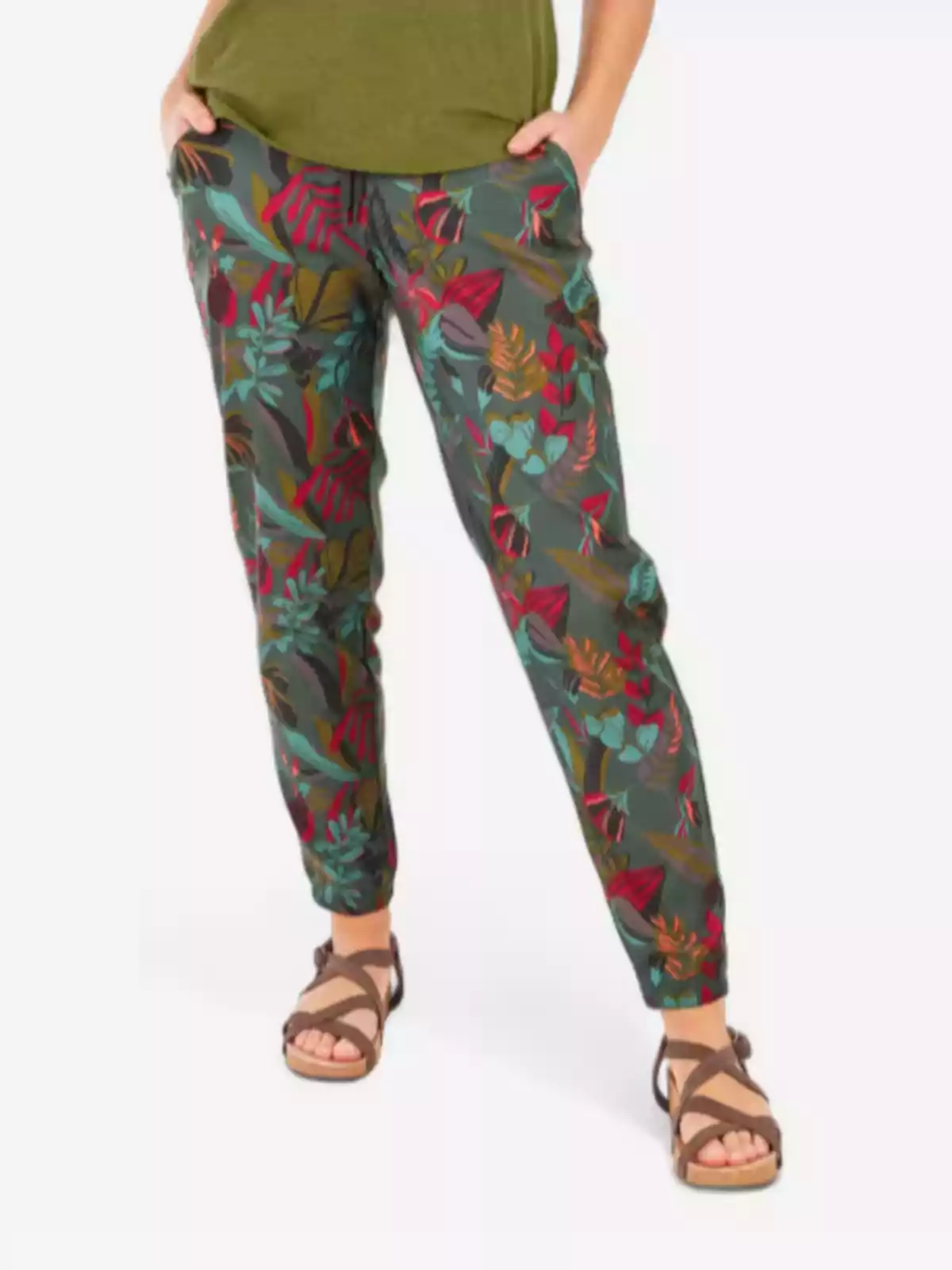 Persona vistiendo pantalones con estampado de hojas coloridas y sandalias marrones Persona vistiendo pantalones con estampado de hojas coloridas y sandalias marrones