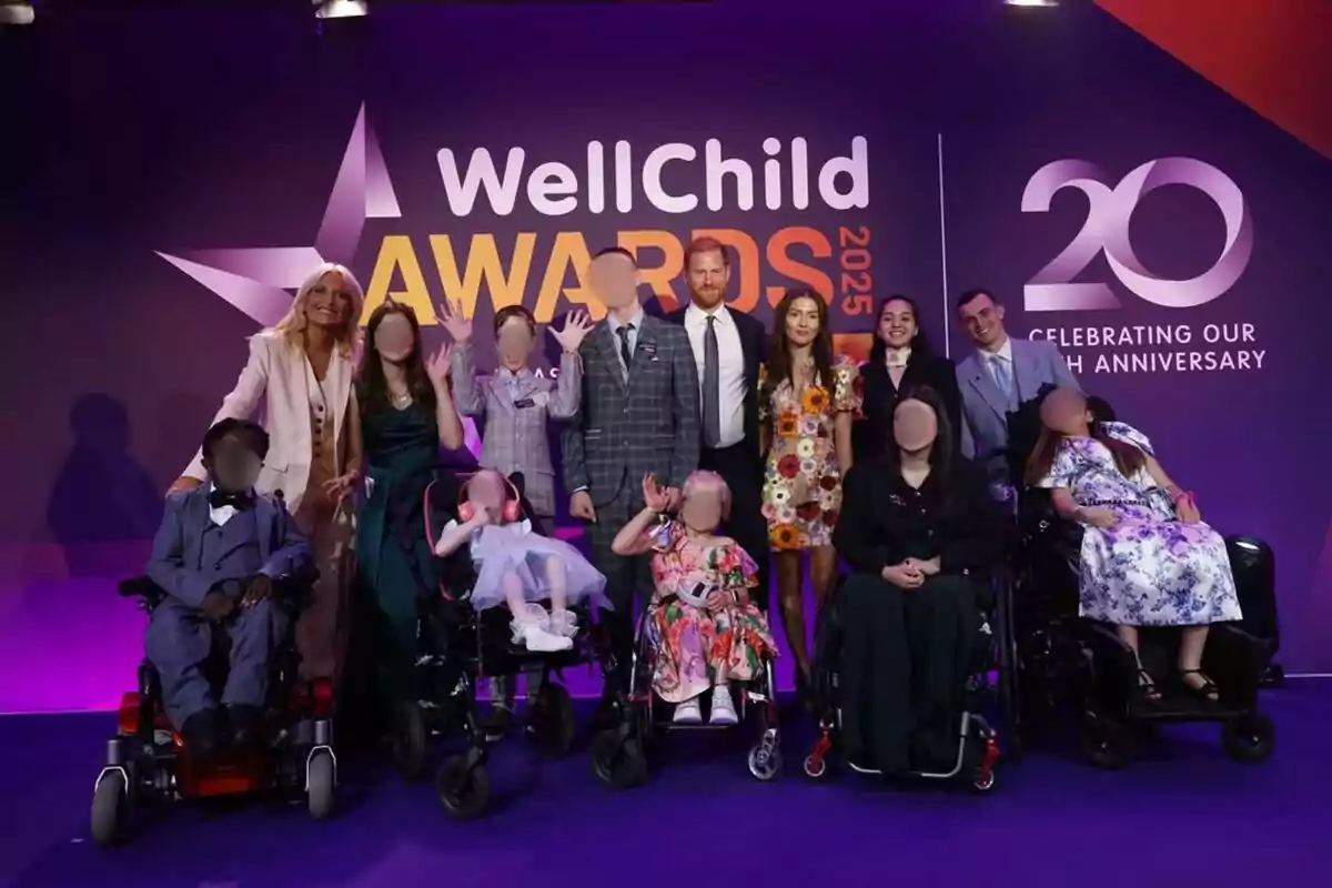 Grupo de personas posando sonrientes en un evento de premiación WellChild Awards 2025 con fondo morado y logotipo del 20 aniversario, varias personas en sillas de ruedas y todos vestidos de manera elegante