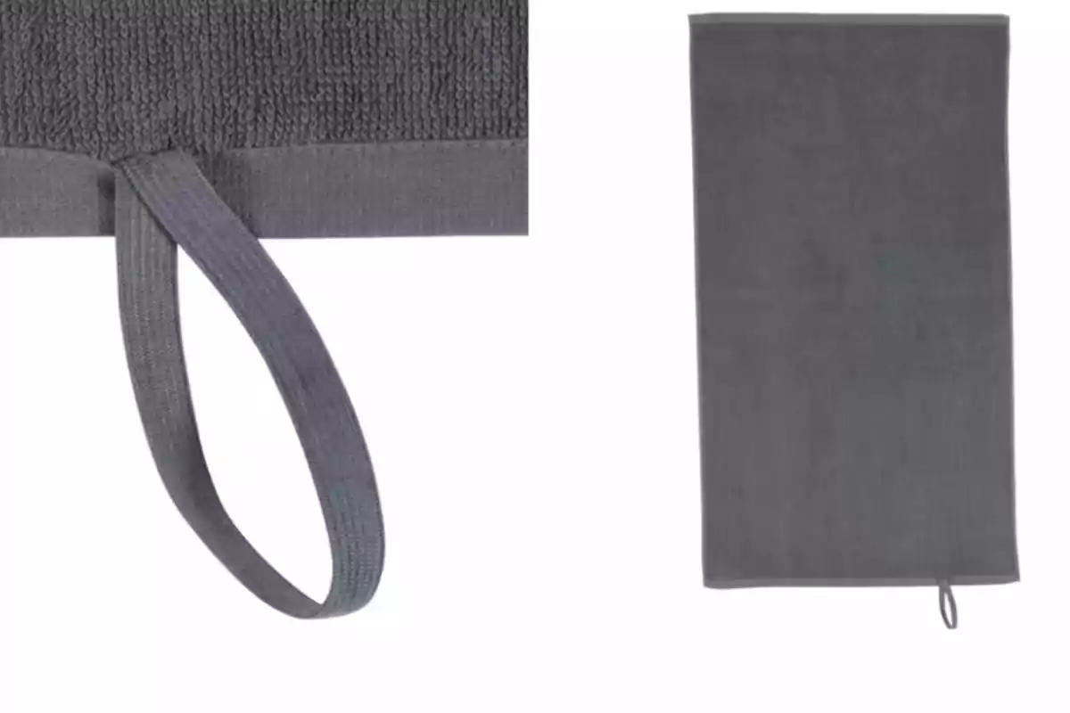 Toalla de color gris con una cinta para colgar en una de las esquinas Toalla de color gris con una cinta para colgar en una de las esquinas