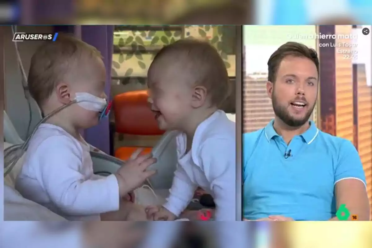 Dos bebés pequeños interactúan en una habitación de hospital mientras un hombre joven con barba y camiseta azul habla en un programa de televisión. Dos bebés pequeños interactúan en una habitación de hospital mientras un hombre joven con barba y camiseta azul habla en un programa de televisión.