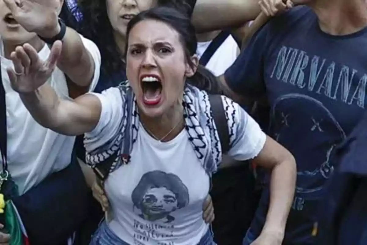 Mujer gritando con expresión de enojo en medio de una multitud durante una protesta
