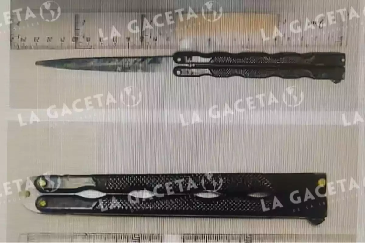 Navaja tipo mariposa negra mostrada en dos posiciones junto a una regla para referencia de tamaño Navaja tipo mariposa negra mostrada en dos posiciones junto a una regla para referencia de tamaño