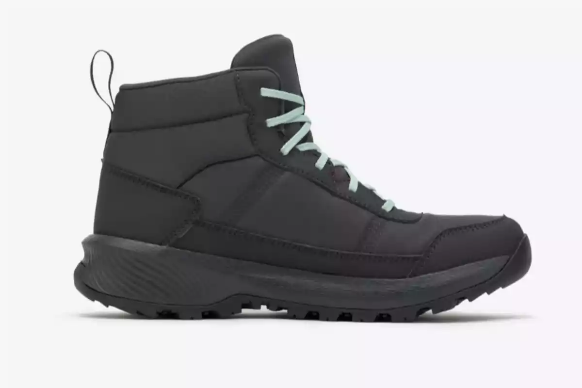 Bota deportiva negra de media caña con agujetas color verde claro sobre fondo blanco Bota deportiva negra de media caña con agujetas color verde claro sobre fondo blanco
