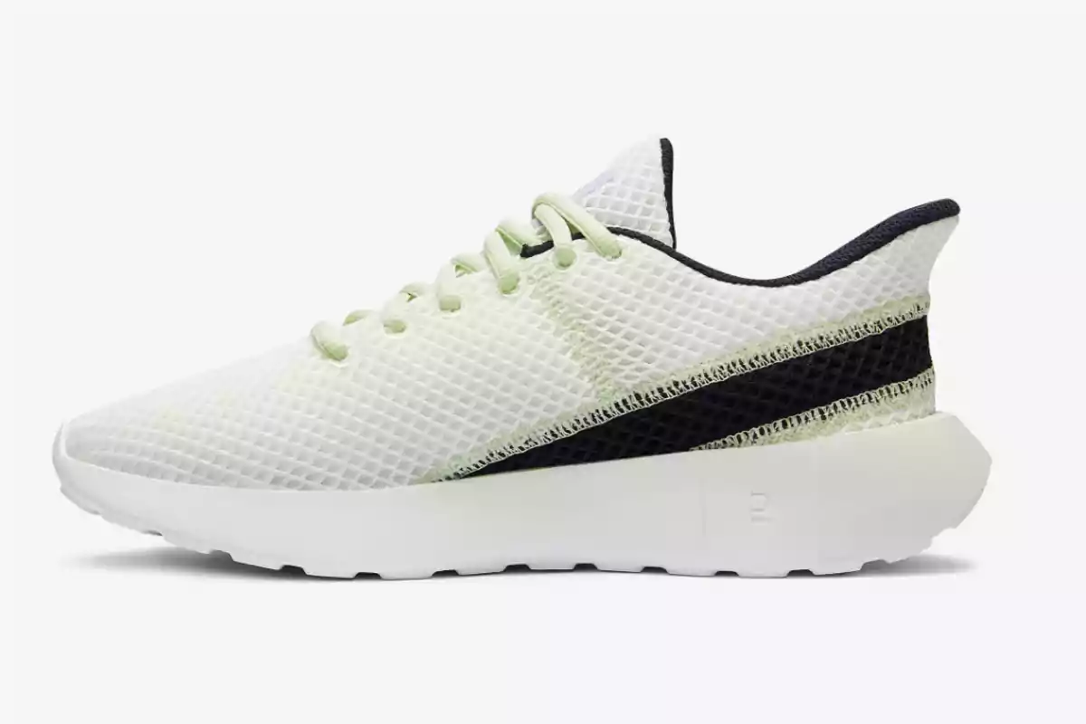 Zapatilla deportiva blanca con detalles en verde claro y una franja negra en el costado sobre fondo blanco