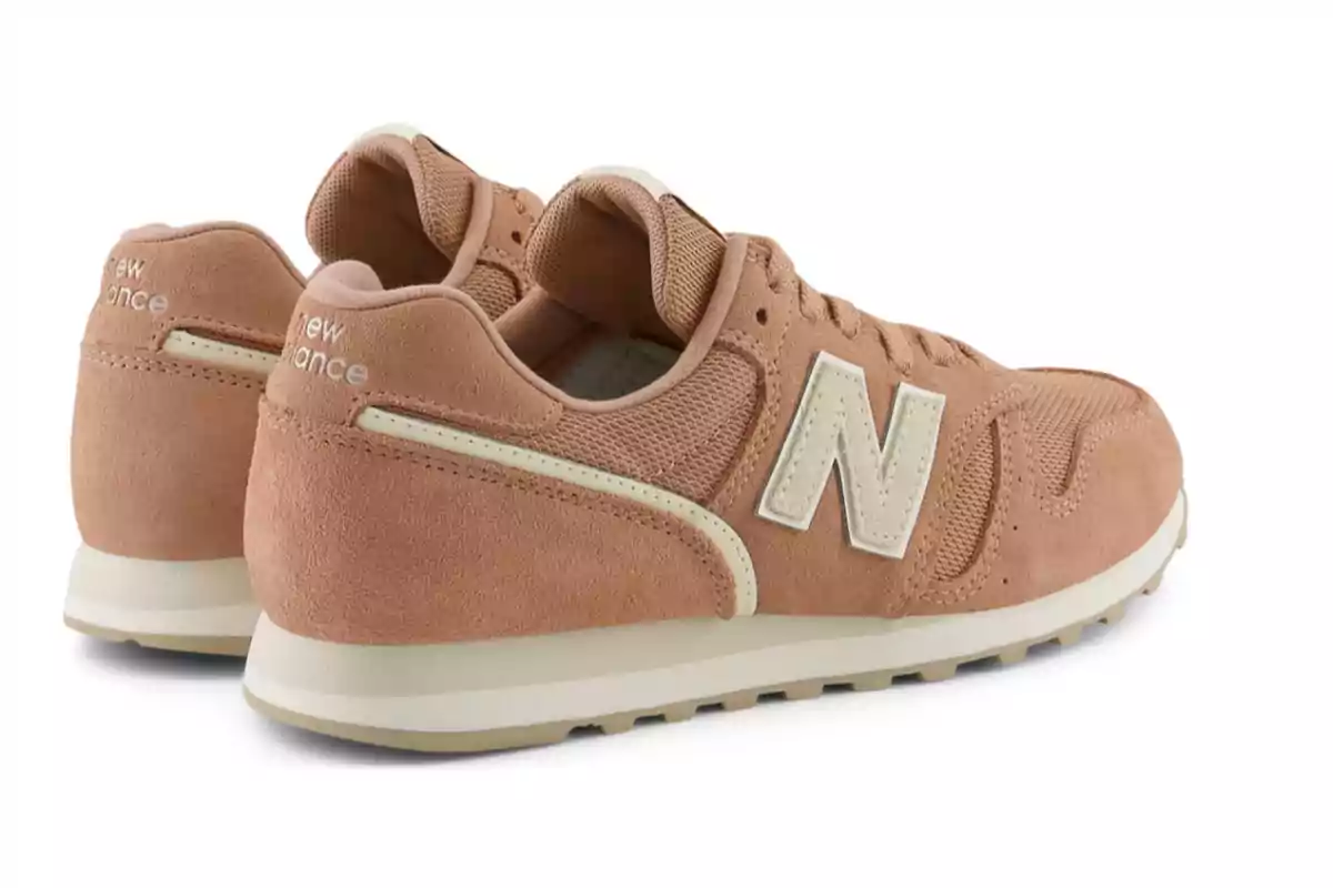 Tenis New Balance color beige con detalles en blanco sobre un fondo blanco