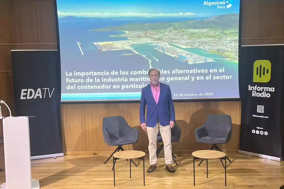 Un hombre de pie en un escenario entre dos sillas frente a una pantalla que muestra una presentación sobre combustibles alternativos en la industria marítima, con banners de EDA TV e Informa Radio a los lados.