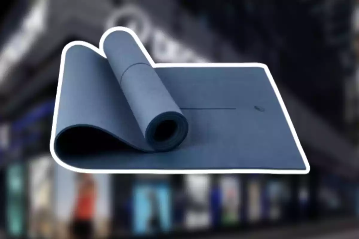 Tapete de yoga azul desenrollado con fondo de tienda desenfocado