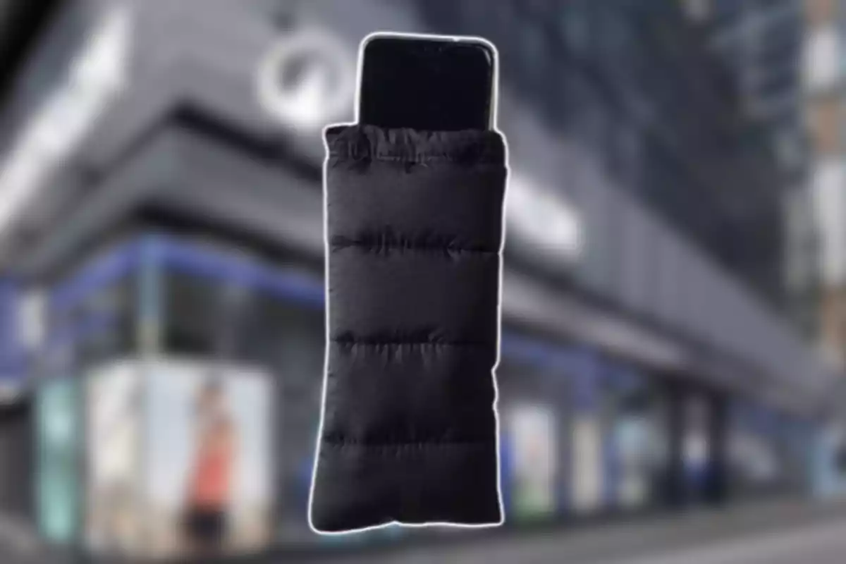 Un teléfono móvil dentro de una funda acolchada negra con un fondo de edificio desenfocado Un teléfono móvil dentro de una funda acolchada negra con un fondo de edificio desenfocado