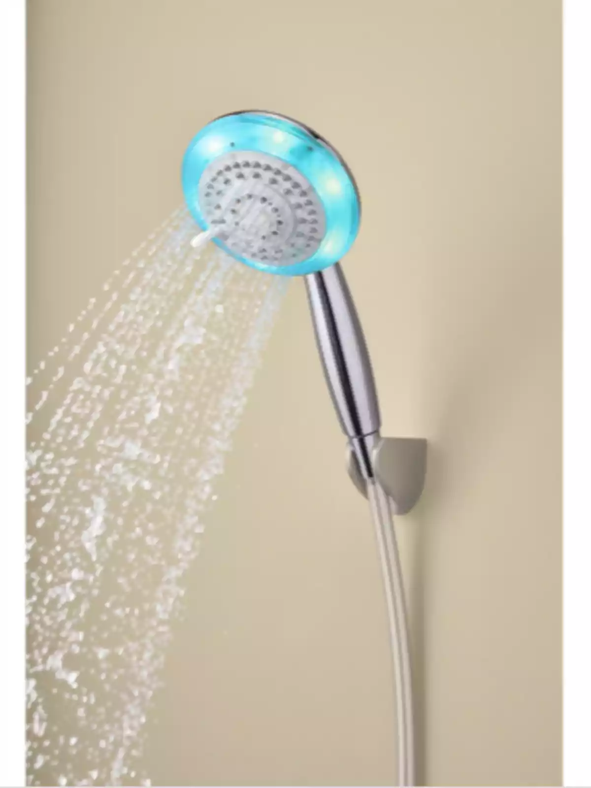Regadera de mano plateada con luces LED azules encendida y expulsando agua contra una pared beige