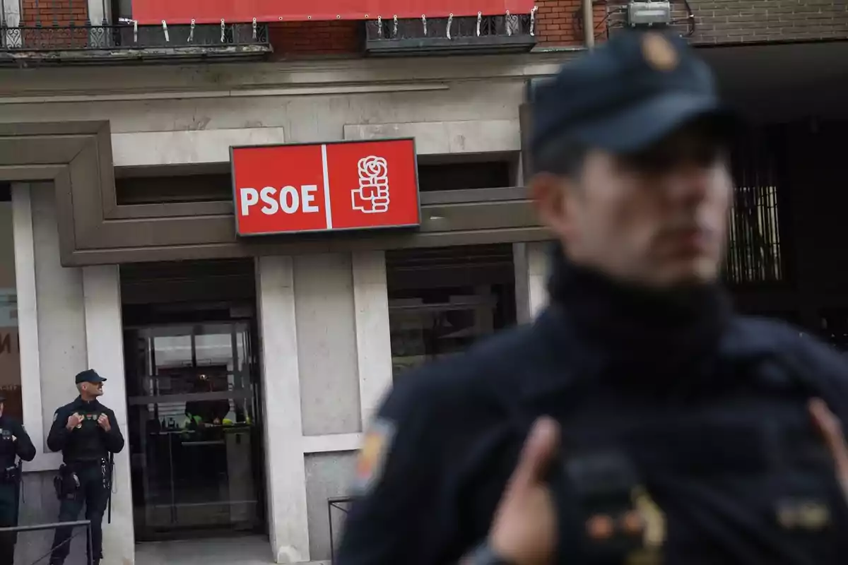 Policías custodian la entrada de un edificio con el letrero del PSOE en la fachada