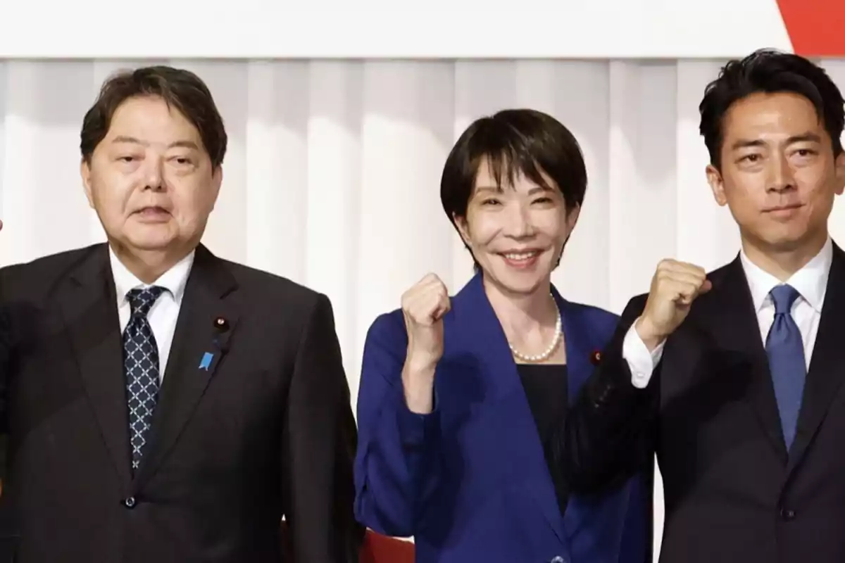 Tres personas vestidas de traje posan sonrientes levantando el puño en señal de celebración o apoyo Tres personas vestidas de traje posan sonrientes levantando el puño en señal de celebración o apoyo