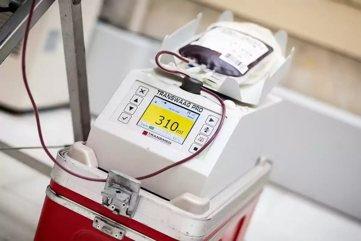Dispositivo médico de medición de sangre con una bolsa de sangre conectada y una pantalla que muestra 310 ml