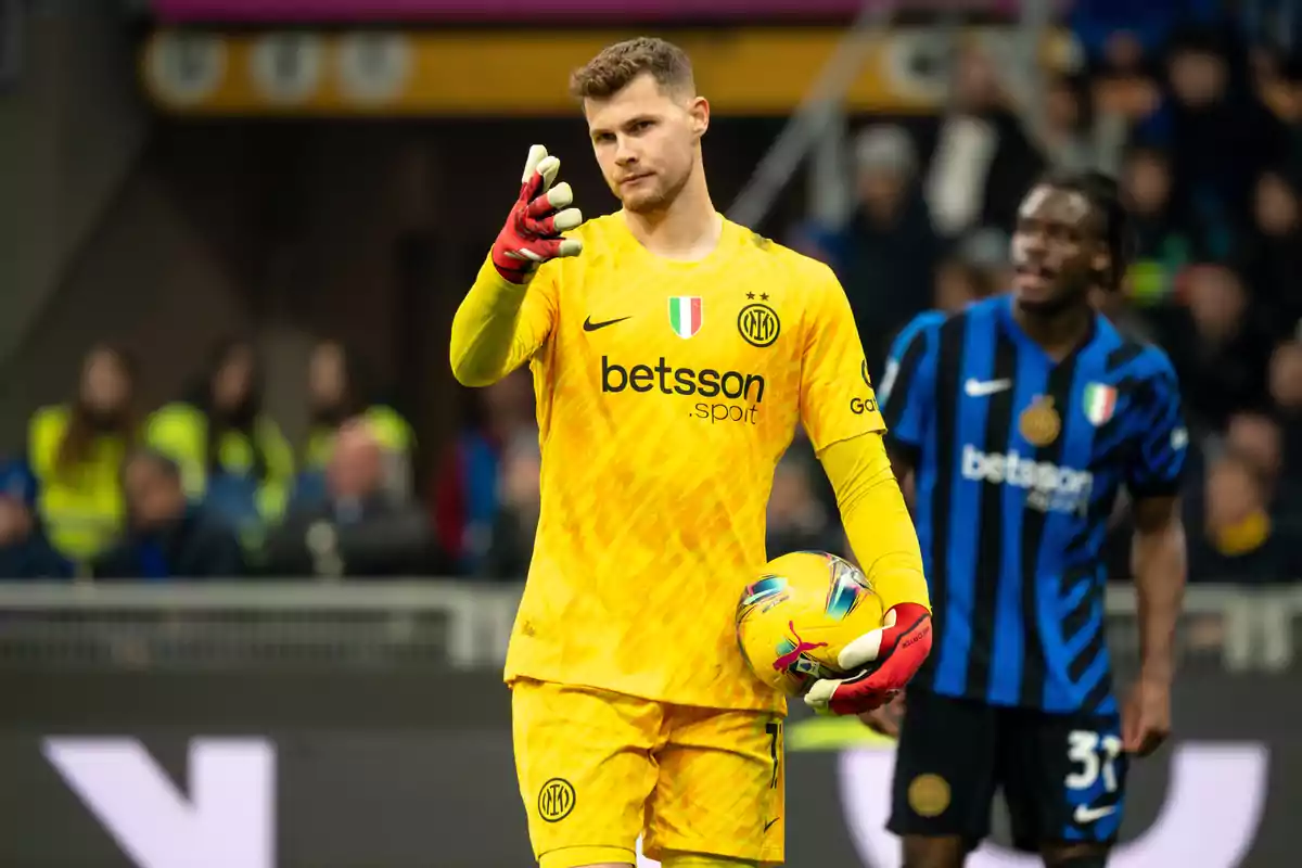 Portero del Inter de Milán con uniforme amarillo sosteniendo un balón durante un partido de fútbol