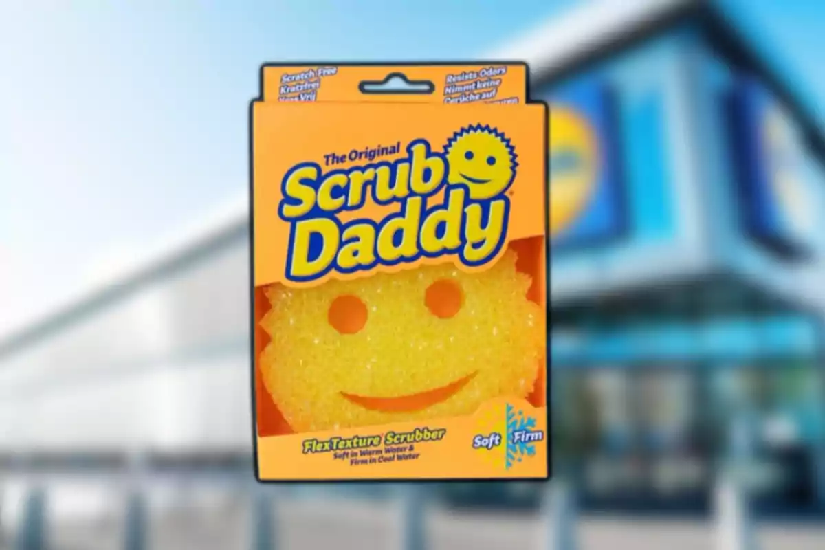 Esponja amarilla Scrub Daddy en su empaque frente a una tienda con fachada azul desenfocada. Esponja amarilla Scrub Daddy en su empaque frente a una tienda con fachada azul desenfocada.