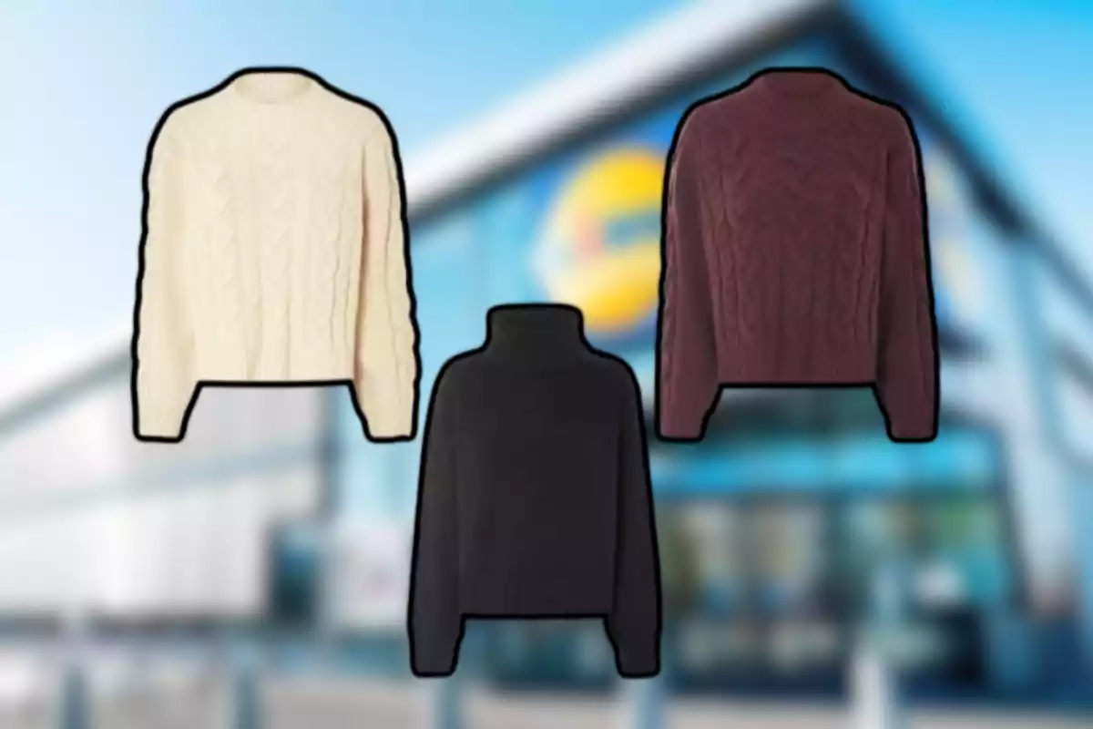 Tres suéteres de diferentes colores están sobre un fondo desenfocado de una tienda
