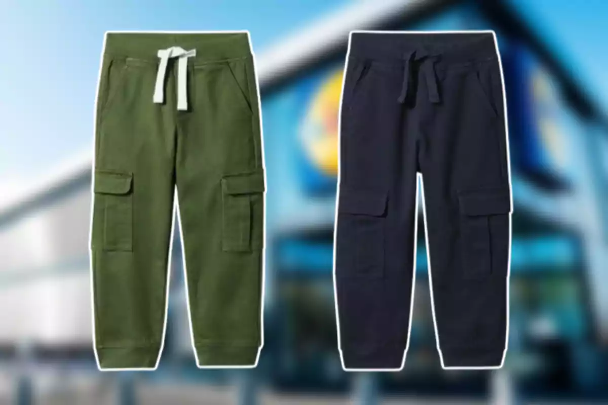Dos pantalones tipo jogger con bolsillos laterales, uno verde con cordón blanco y otro azul marino con cordón del mismo color, sobre un fondo desenfocado de una tienda.