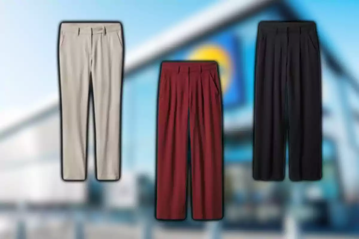 Tres pantalones de vestir en colores beige, rojo y negro sobre un fondo desenfocado de una tienda
