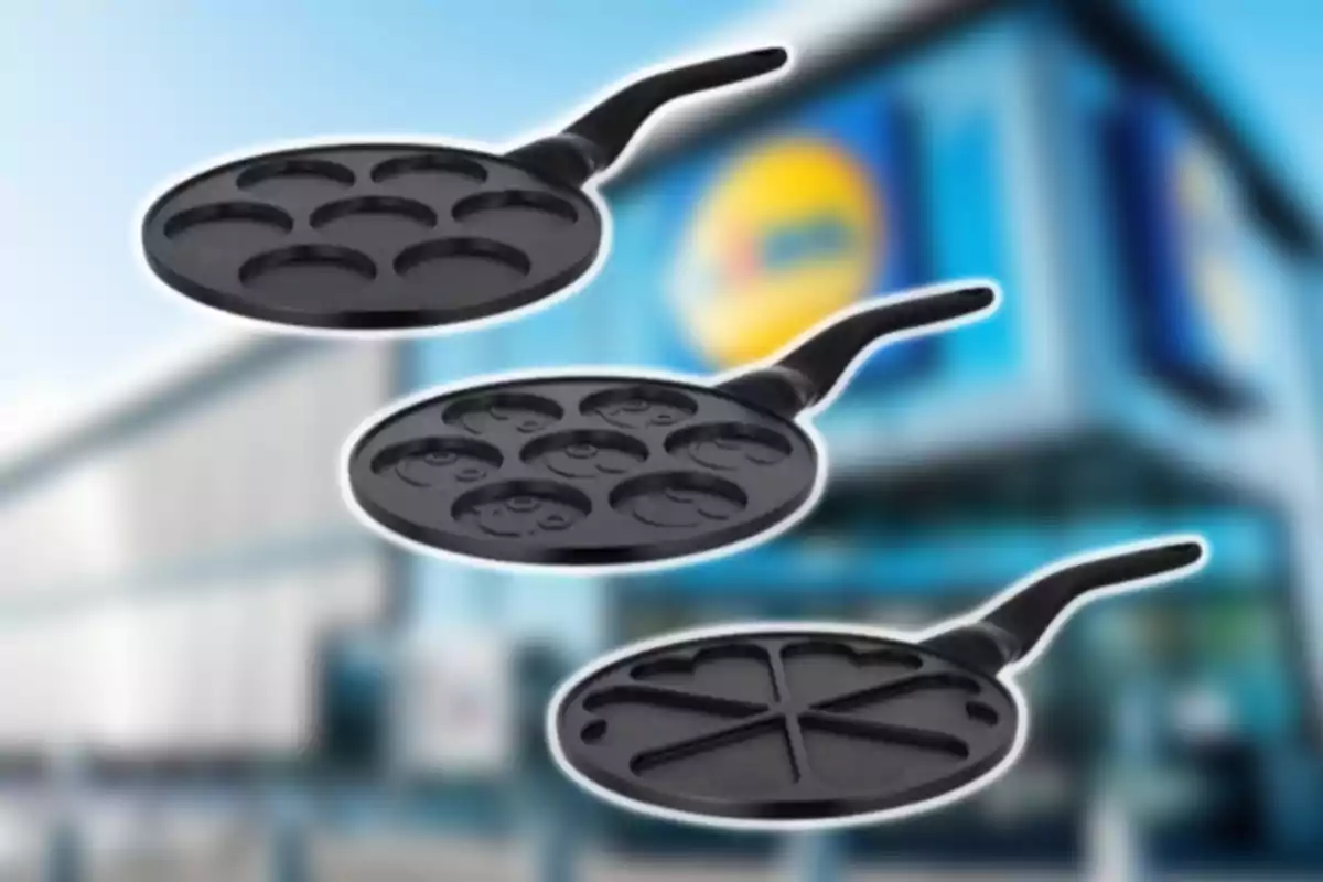 Tres sartenes negras con diferentes moldes para pancakes sobre un fondo borroso de una tienda