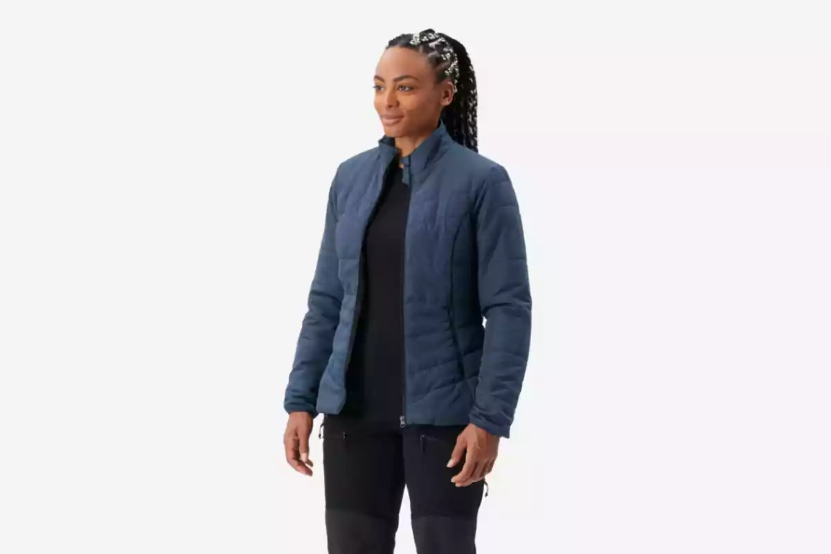 Mujer con chaqueta azul y pantalón negro posando sobre fondo blanco Mujer con chaqueta azul y pantalón negro posando sobre fondo blanco