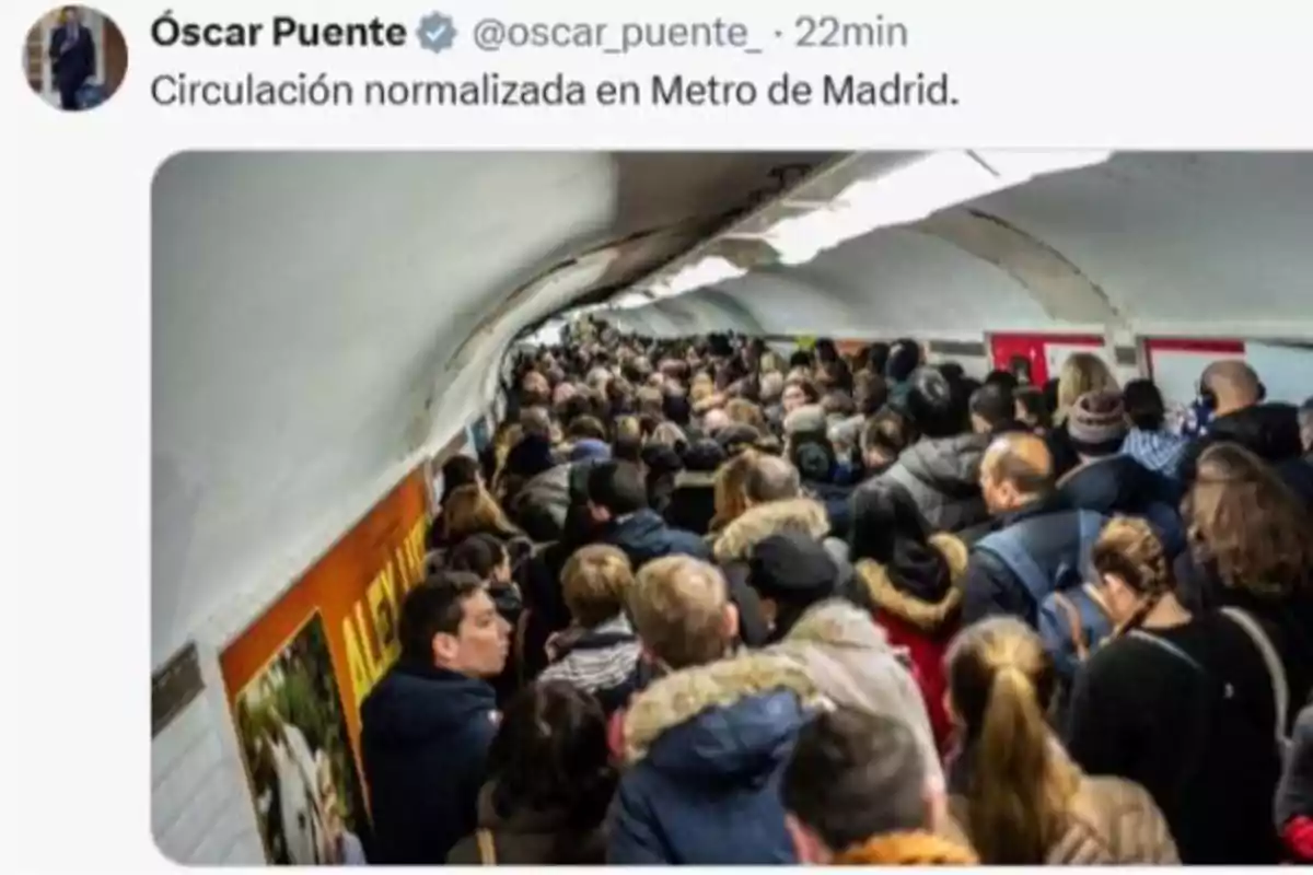 Andén del metro de Madrid lleno de personas caminando en ambas direcciones en hora punta