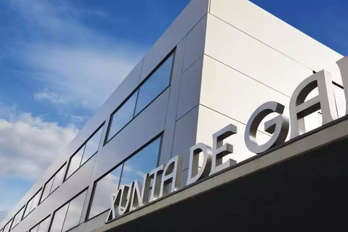 Fachada moderna de un edificio con el letrero Xunta de Galicia y cielo azul de fondo