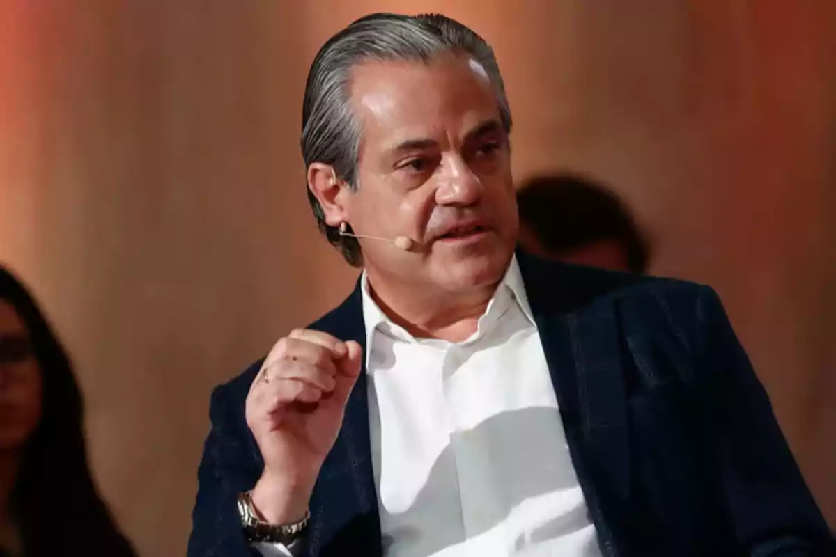 Hombre de cabello canoso usando micrófono de diadema y hablando en un evento