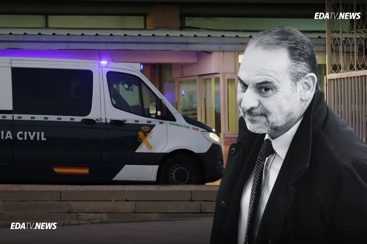 Un hombre de traje en primer plano con expresión seria y una furgoneta de la Guardia Civil estacionada frente a un edificio al fondo