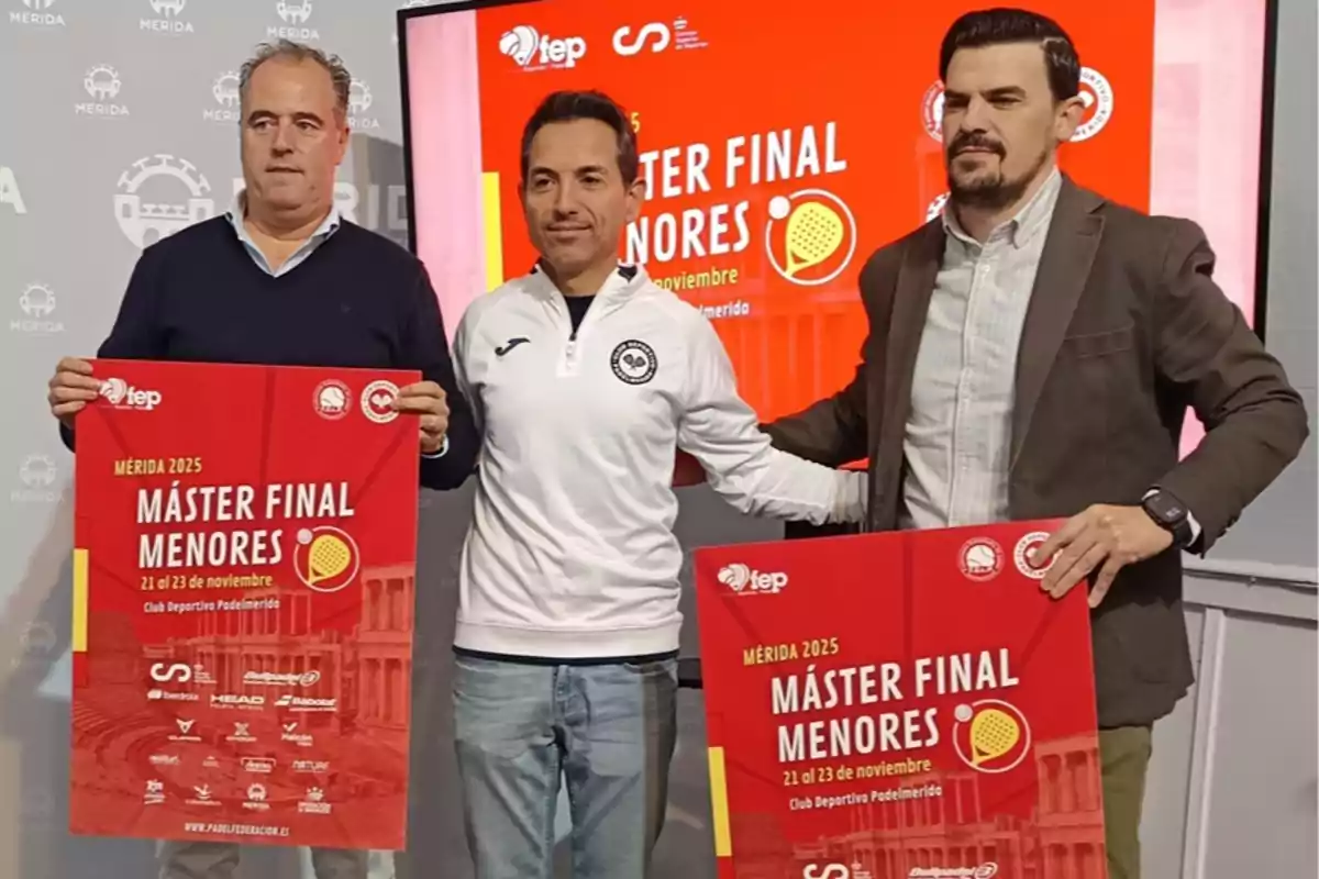 Tres hombres posan frente a una pantalla y sostienen carteles rojos que anuncian el Máster Final Menores 2025 en Mérida