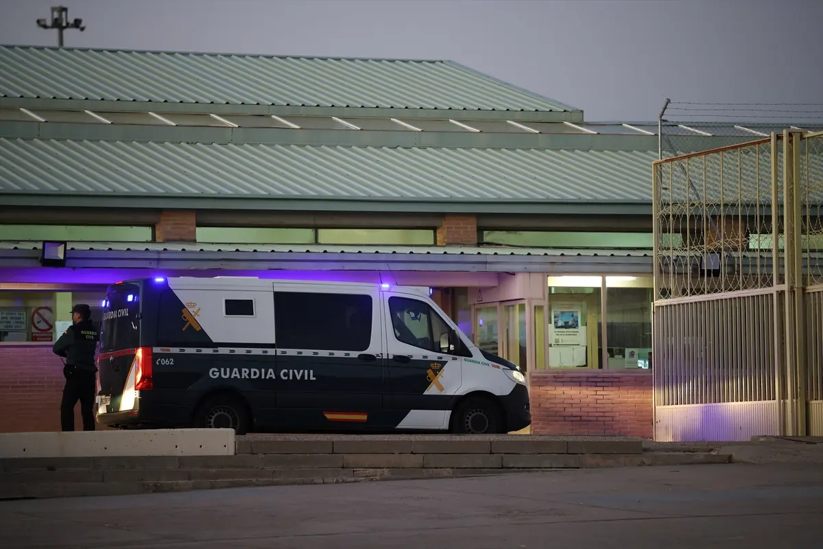 Furgón de la Guardia Civil estacionado junto a la entrada de un edificio con un agente de pie cerca de la puerta Furgón de la Guardia Civil estacionado junto a la entrada de un edificio con un agente de pie cerca de la puerta