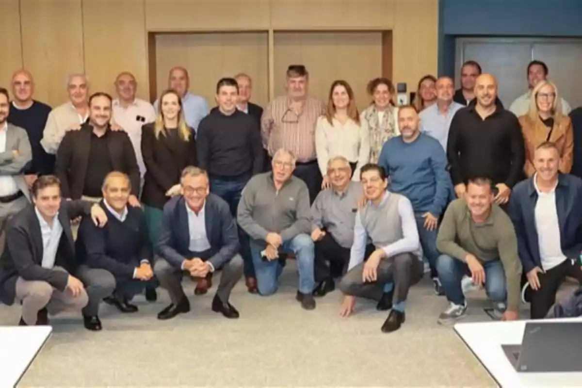 Grupo de personas posando juntas en una sala de reuniones