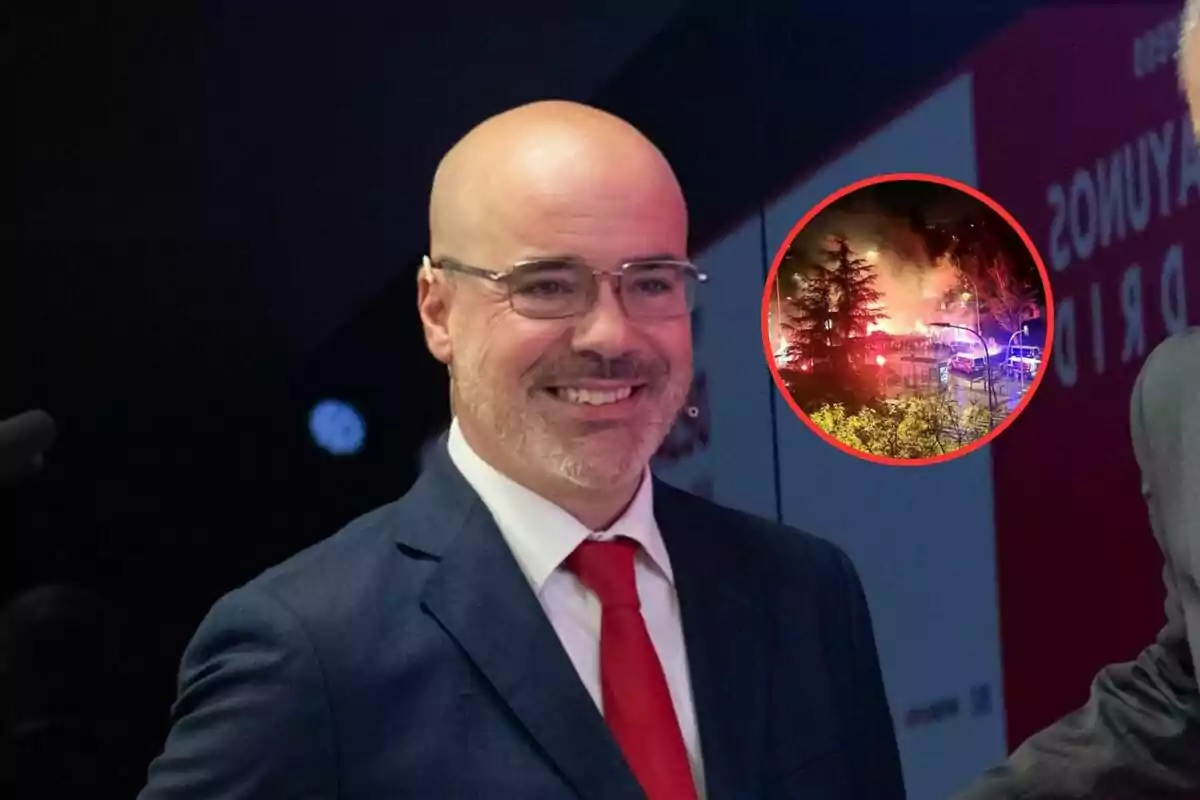 Hombre calvo con gafas y barba sonríe vistiendo traje azul y corbata roja, al fondo aparece un círculo con la imagen de un incendio rodeado de árboles y luces de emergencia.