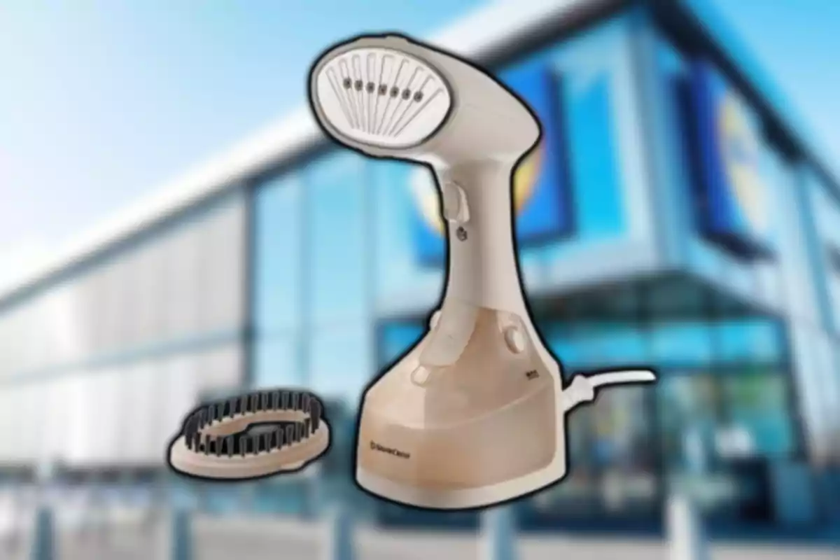 Plancha de vapor portátil de color beige con un accesorio de cepillo sobre un fondo borroso de edificio moderno