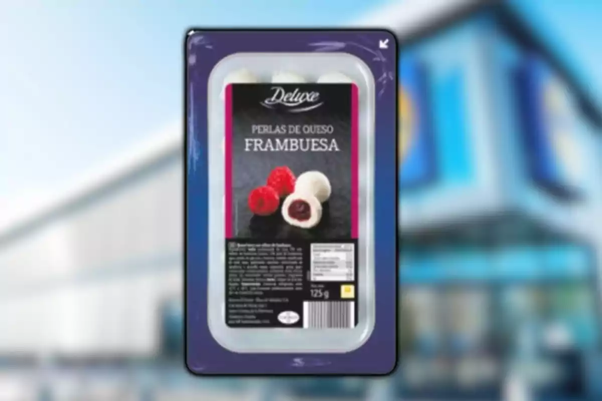 Envase de perlas de queso con frambuesa de la marca Deluxe frente a un fondo borroso de supermercado Envase de perlas de queso con frambuesa de la marca Deluxe frente a un fondo borroso de supermercado
