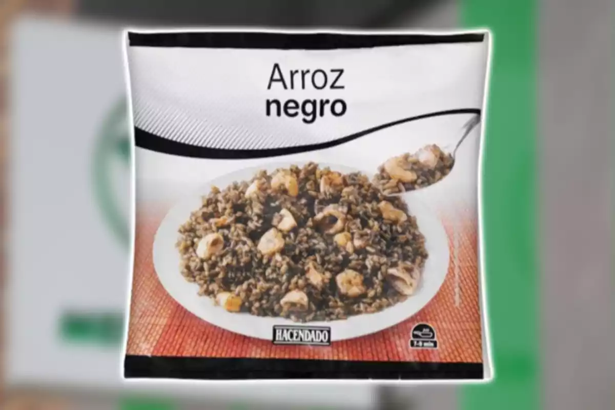 Paquete de arroz negro de la marca Hacendado con una imagen de arroz con mariscos en un plato blanco.