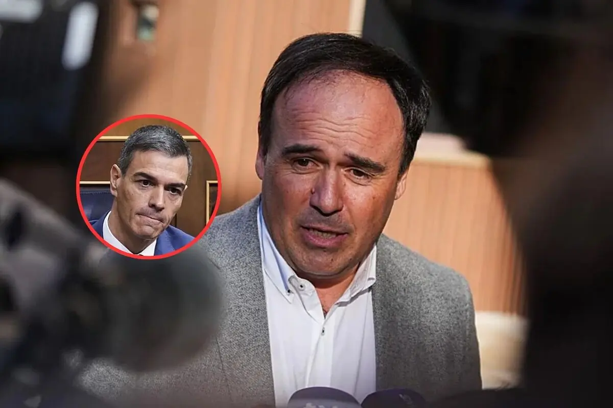 Un hombre con chaqueta gris habla frente a micrófonos mientras en la esquina aparece el rostro de otro hombre dentro de un círculo rojo