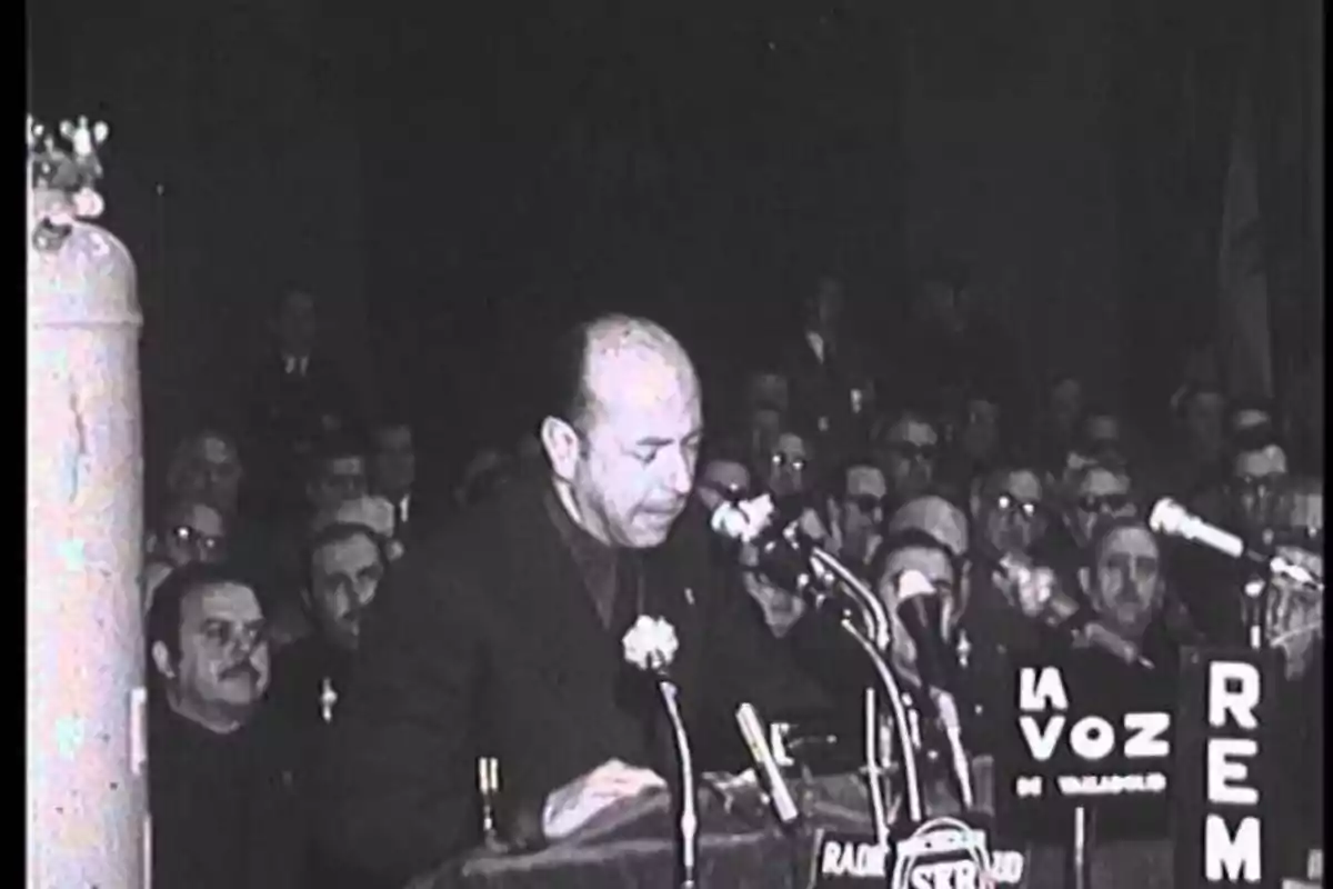 José Utrera Molina mientras una multitud lo observa atentamente en un evento formal en blanco y negro