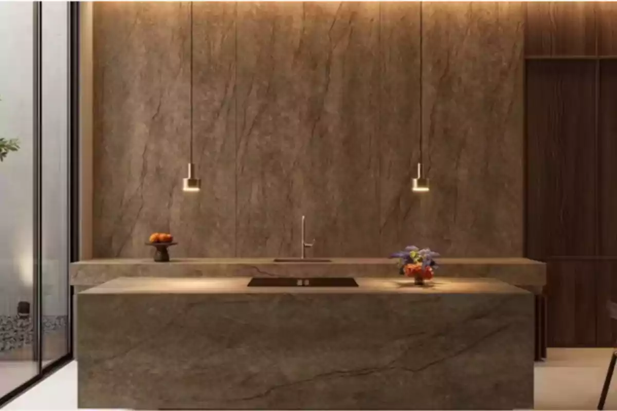 Cocina moderna con isla de mármol marrón, lámparas colgantes, un florero con flores y un frutero sobre la encimera Cocina moderna con isla de mármol marrón, lámparas colgantes, un florero con flores y un frutero sobre la encimera