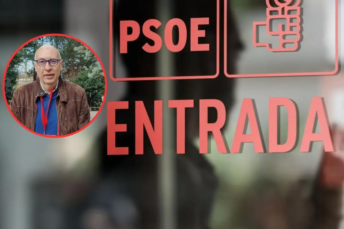 Cartel de entrada a una sede del PSOE con letras rojas y un recuadro circular que muestra a un hombre calvo con gafas y chaqueta marrón delante de unos árboles