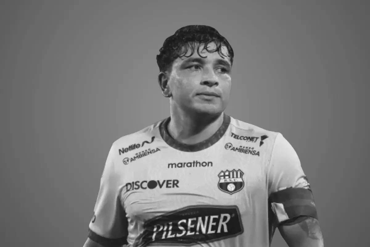 Futbolista con camiseta blanca de Barcelona SC mirando hacia la derecha sobre fondo gris