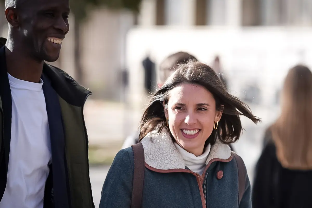 Dos personas sonríen mientras caminan al aire libre en un día soleado