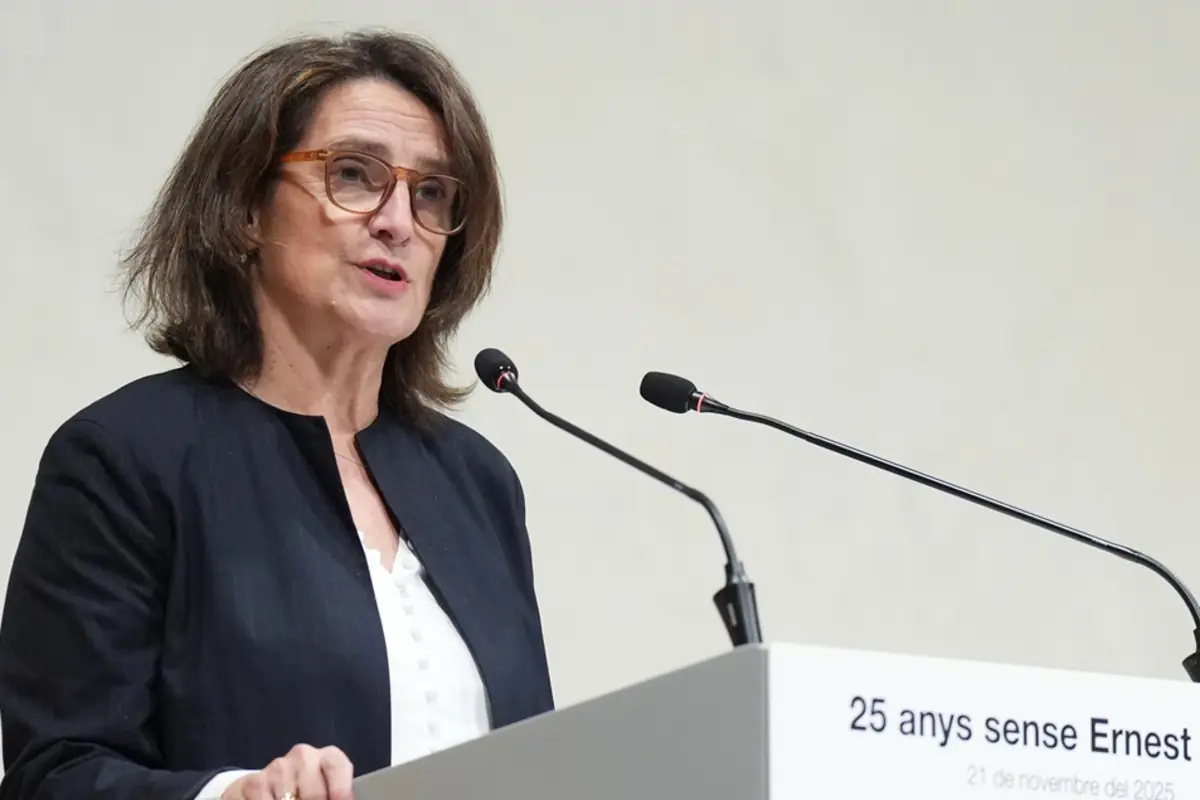 Mujer con gafas hablando en un atril con dos micrófonos durante un acto conmemorativo Mujer con gafas hablando en un atril con dos micrófonos durante un acto conmemorativo
