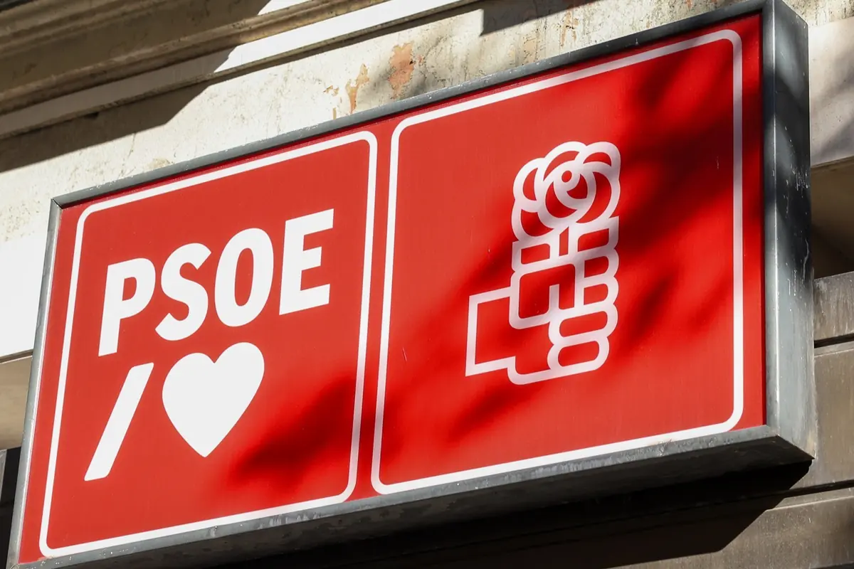 Letrero rojo del PSOE con un corazón blanco y el símbolo de un puño sosteniendo una rosa