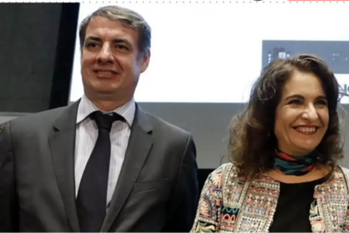 Dos personas sonríen mientras posan juntas en un evento formal. Dos personas sonríen mientras posan juntas en un evento formal.