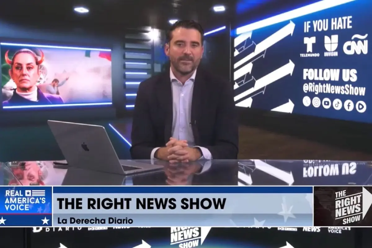 Un hombre con barba y saco oscuro está sentado en un estudio de noticias con pantallas digitales al fondo, una de ellas muestra una imagen editada de una mujer con cuernos y otra invita a seguir el programa en redes sociales.