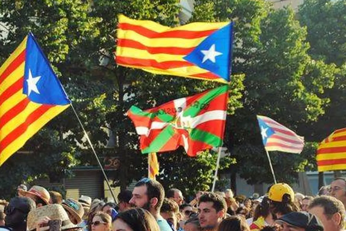 Multitud de personas en una manifestación al aire libre ondeando banderas independentistas catalanas vascas y puertorriqueñas Multitud de personas en una manifestación al aire libre ondeando banderas independentistas catalanas vascas y puertorriqueñas